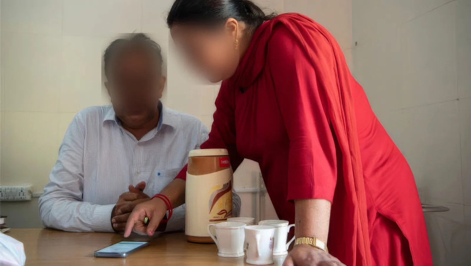 A CHO leaning in to show a doctor the prototype on a phone, faces blurred